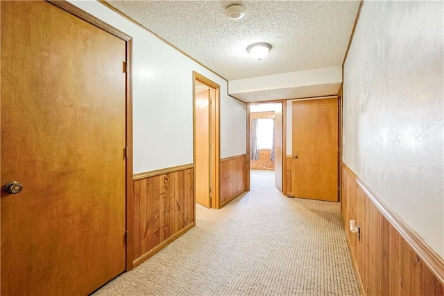 3402 Messanie St, Saint Joseph, MO 64501 - hall featuring a wainscoted wall, a textured ceiling, wooden walls, and light colored carpet
