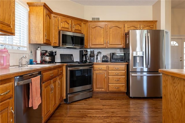 3015 SW 9th Ter, Lees Summit, MO 64081 - kitchen with brown cabinets, visible vents, decorative backsplash, and stainless steel appliances