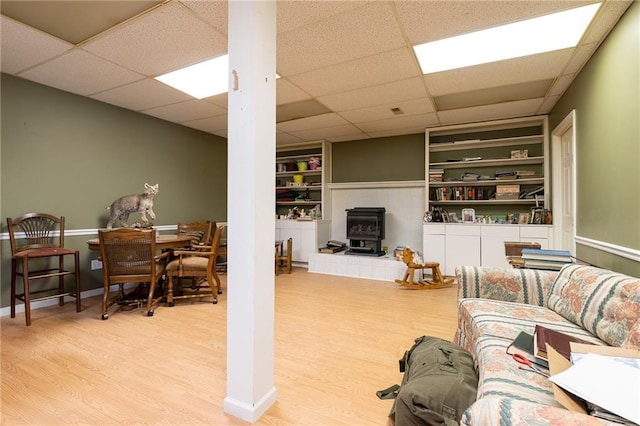 3015 SW 9th Ter, Lees Summit, MO 64081 - living room featuring built in features, a wood stove, a paneled ceiling, and wood finished floors