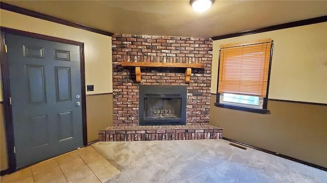 616 E Jackson E, Jackson, Pittsburg, KS 66762 - unfurnished living room featuring carpet flooring, visible vents, crown molding, a brick fireplace, and tile patterned flooring
