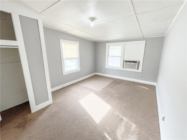 unfurnished bedroom featuring cooling unit, carpet floors, baseboards, and vaulted ceiling