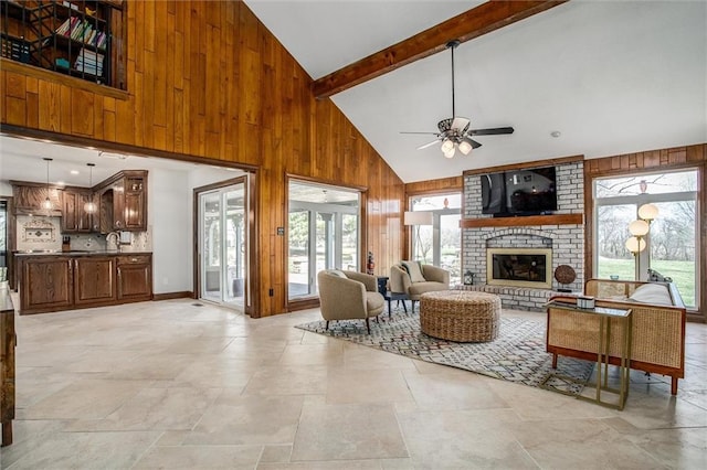 9701 Timber Meadows Dr, Lees Summit, MO 64086 - living area with high vaulted ceiling, wood walls, stone tile floors, ceiling fan, and a fireplace