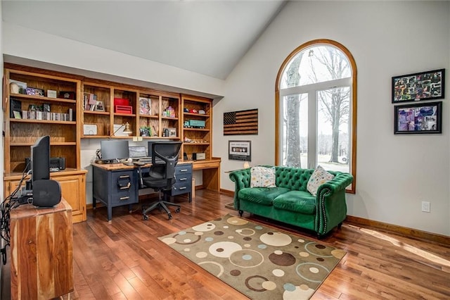 9701 Timber Meadows Dr, Lees Summit, MO 64086 - office area featuring dark wood-style flooring, baseboards, high vaulted ceiling, and built in desk