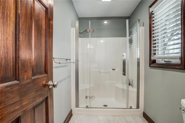 9701 Timber Meadows Dr, Lees Summit, MO 64086 - full bathroom featuring a stall shower, baseboards, and toilet