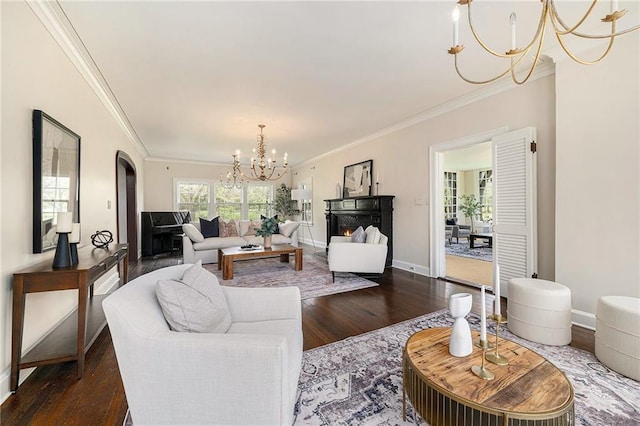 5760 Ward Pkwy, Kansas City, MO 64113 - living room with crown molding, arched walkways, a chandelier, dark wood finished floors, and baseboards