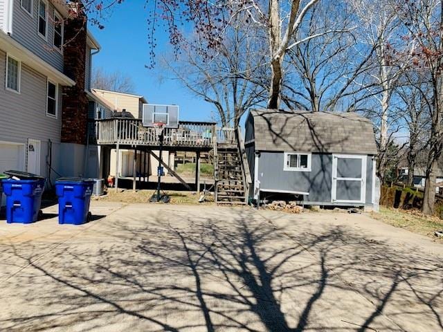 exterior space featuring stairway, driveway, a storage shed, and an outdoor structure