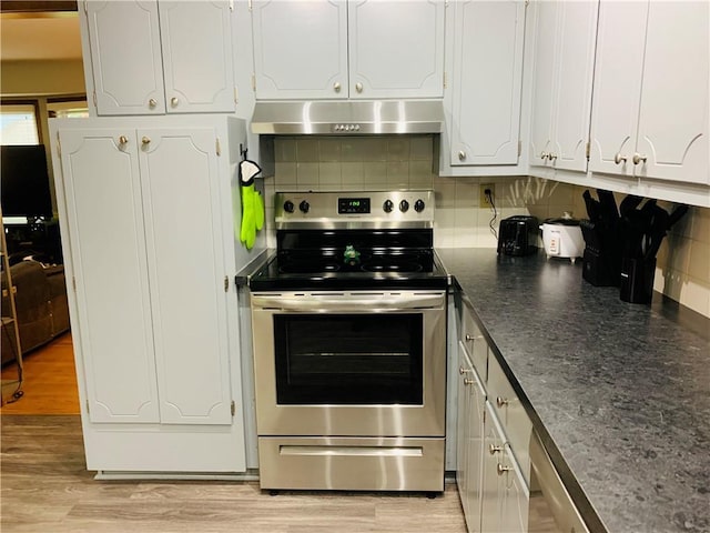 kitchen featuring white cabinets, stainless steel electric range oven, light wood finished floors, tasteful backsplash, and under cabinet range hood