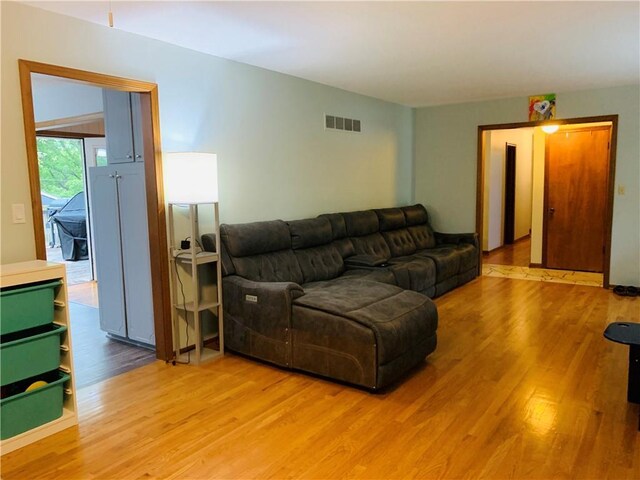 living room with visible vents and light wood-type flooring