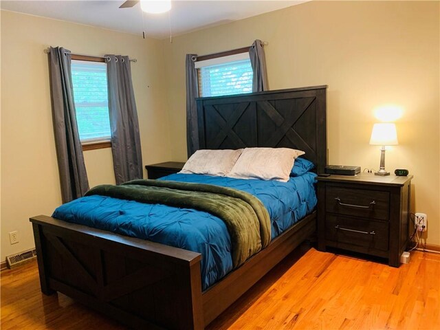 bedroom with baseboards, visible vents, multiple windows, and light wood-style flooring