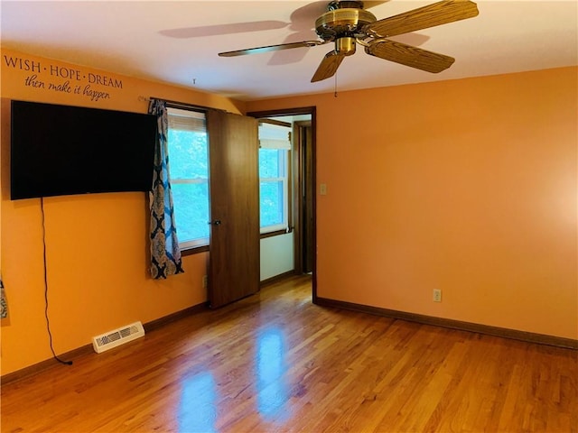 empty room with visible vents, baseboards, ceiling fan, and light wood-type flooring