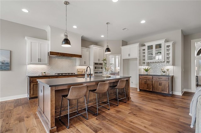 9238 Marion St, Lenexa, KS 66220 - kitchen featuring dark countertops, a sink, stainless steel double oven, white cabinets, and recessed lighting