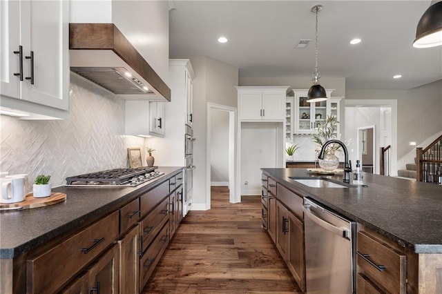 9238 Marion St, Lenexa, KS 66220 - kitchen featuring appliances with stainless steel finishes, wall chimney exhaust hood, a sink, dark wood-style floors, and tasteful backsplash