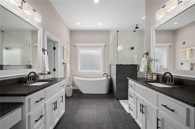 9238 Marion St, Lenexa, KS 66220 - bathroom with a stall shower, two vanities, a freestanding bath, tile patterned flooring, and recessed lighting