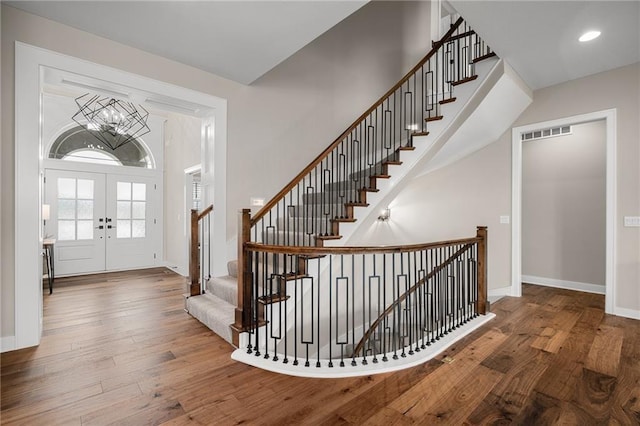 9238 Marion St, Lenexa, KS 66220 - foyer entrance featuring french doors, hardwood / wood-style flooring, a chandelier, baseboards, and stairs
