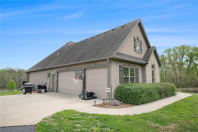 15511 Salem Rd, Excelsior Springs, MO 64024 - view of side of home with a garage, concrete driveway, stucco siding, and stone siding