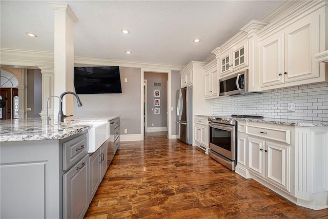 15511 Salem Rd, Excelsior Springs, MO 64024 - kitchen featuring appliances with stainless steel finishes, ornate columns, a sink, gray cabinetry, and baseboards