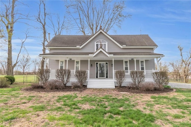 view of front of house featuring covered porch, a tile roof, and a front yard