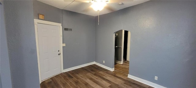 224 Spruce St, Leavenworth, KS 66048 - spare room with visible vents, baseboards, dark wood finished floors, arched walkways, and a ceiling fan