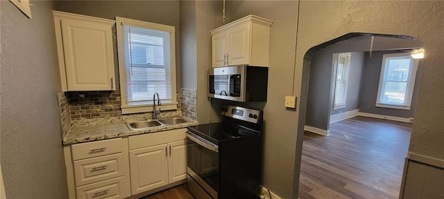 224 Spruce St, Leavenworth, KS 66048 - kitchen featuring decorative backsplash, appliances with stainless steel finishes, dark wood-style flooring, and a sink