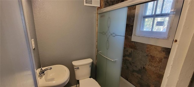 224 Spruce St, Leavenworth, KS 66048 - full bath featuring an enclosed shower, toilet, a textured wall, and a sink