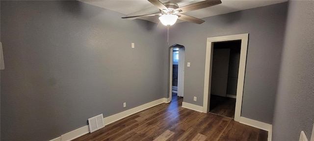 224 Spruce St, Leavenworth, KS 66048 - spare room with dark wood-style floors, a ceiling fan, visible vents, baseboards, and arched walkways