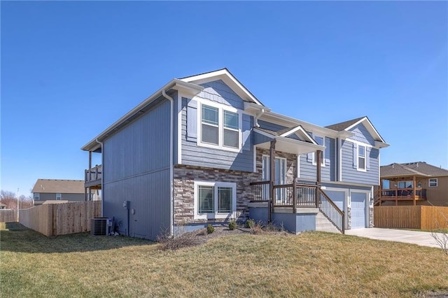 815 S Sunset Ln, Raymore, MO 64083 - bi-level home with concrete driveway, stone siding, and a garage