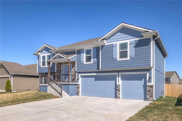 815 S Sunset Ln, Raymore, MO 64083 - bi-level home with a garage, stone siding, concrete driveway, and stairs