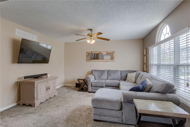 living room featuring baseboards, a textured ceiling, visible vents, ceiling fan, and carpet