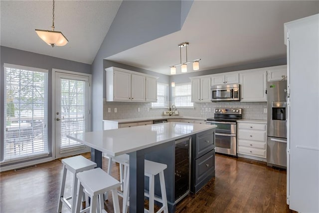 kitchen with a sink, light countertops, tasteful backsplash, and stainless steel appliances