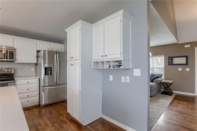 kitchen featuring light countertops, white cabinets, appliances with stainless steel finishes, and dark wood-style floors