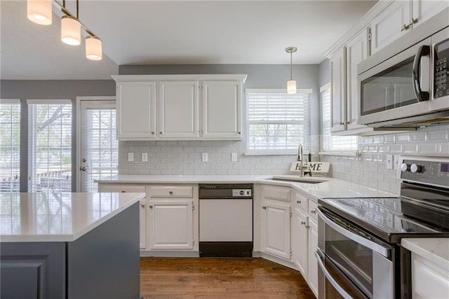 kitchen featuring a sink, decorative backsplash, appliances with stainless steel finishes, and white cabinetry
