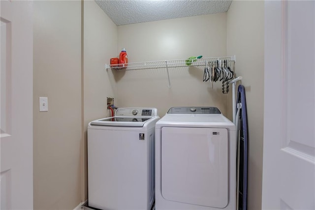 laundry area with laundry area, separate washer and dryer, and a textured ceiling
