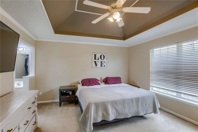 bedroom featuring crown molding, a ceiling fan, light carpet, a raised ceiling, and baseboards