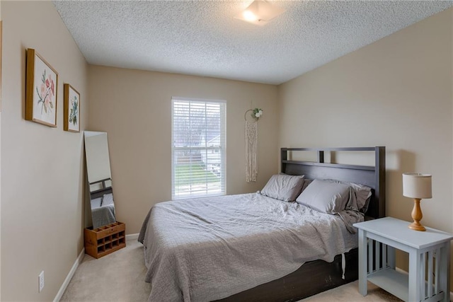 carpeted bedroom featuring baseboards and a textured ceiling