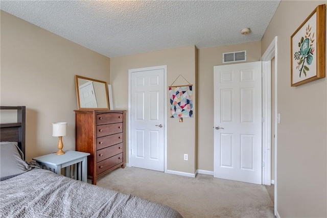 bedroom with visible vents, baseboards, carpet flooring, and a textured ceiling