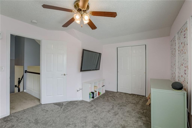 unfurnished bedroom featuring a textured ceiling, a closet, ceiling fan, and carpet floors