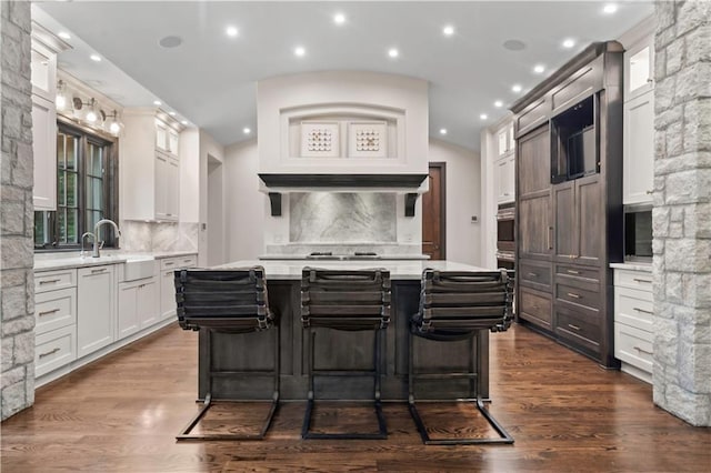 10408 Howe Ln, Leawood, KS 66206 - kitchen featuring white cabinets, dark wood finished floors, a center island, decorative backsplash, and glass insert cabinets