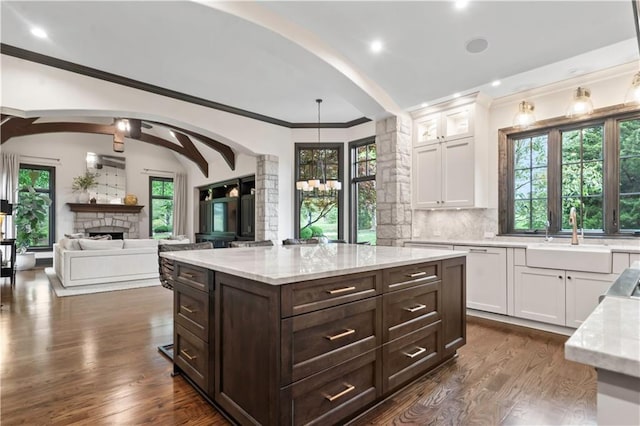 10408 Howe Ln, Leawood, KS 66206 - kitchen with white cabinetry, arched walkways, a sink, and dark brown cabinets