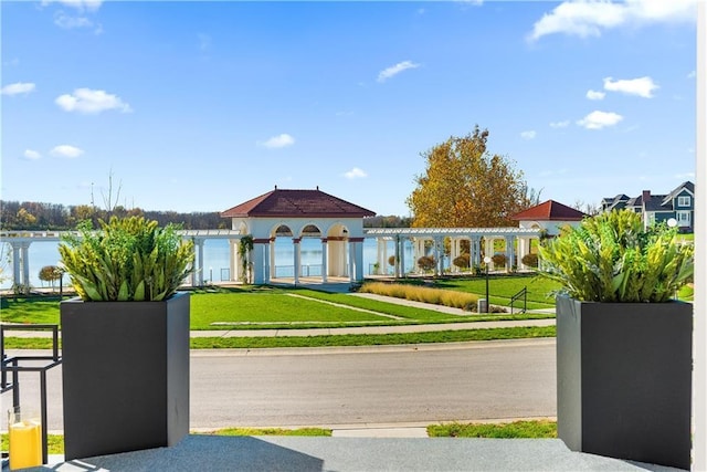 view of community with a lawn and a water view