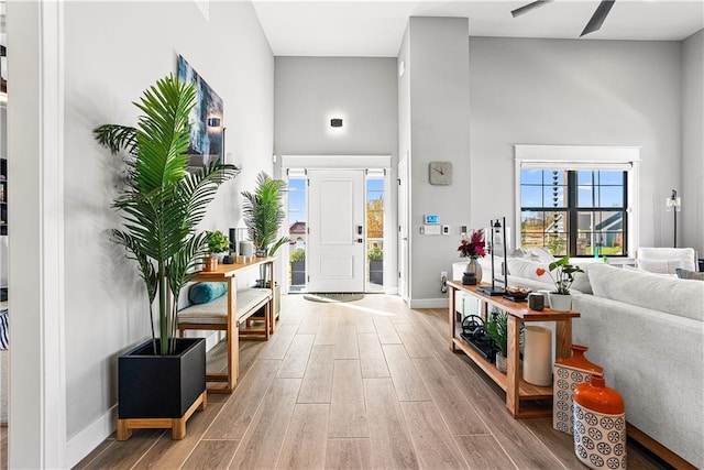 entrance foyer featuring a high ceiling, light wood-style flooring, and baseboards