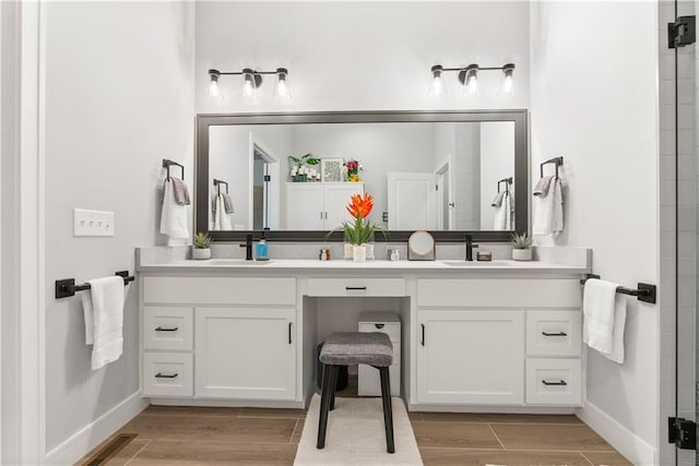 full bathroom with double vanity, a sink, visible vents, and wood tiled floor