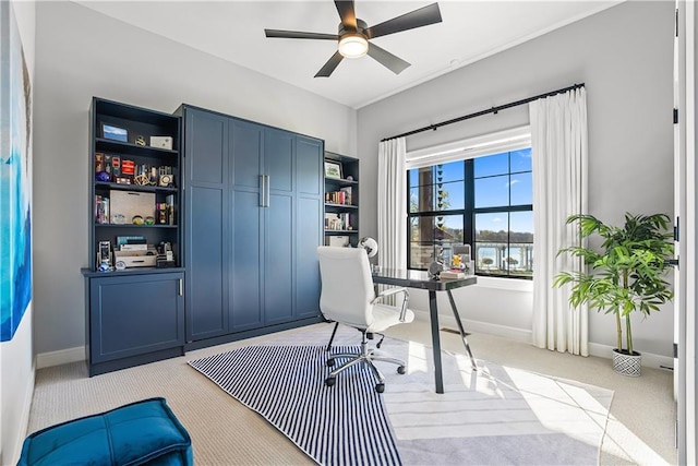home office with light carpet, baseboards, and a ceiling fan