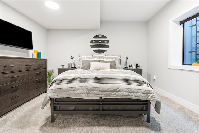 bedroom featuring baseboards and light colored carpet