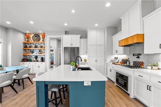 3238 SW Pergola Park Dr, Lees Summit, MO 64081 - kitchen featuring a sink, stainless steel refrigerator, oven, gas cooktop, and a kitchen breakfast bar