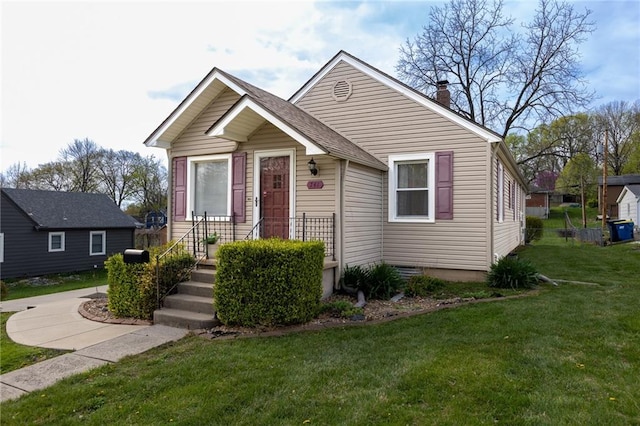 bungalow-style house with a chimney and a front lawn