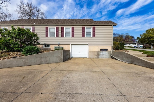 view of side of home featuring a garage and concrete driveway