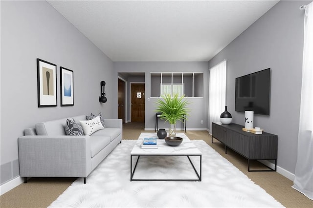carpeted living area with baseboards