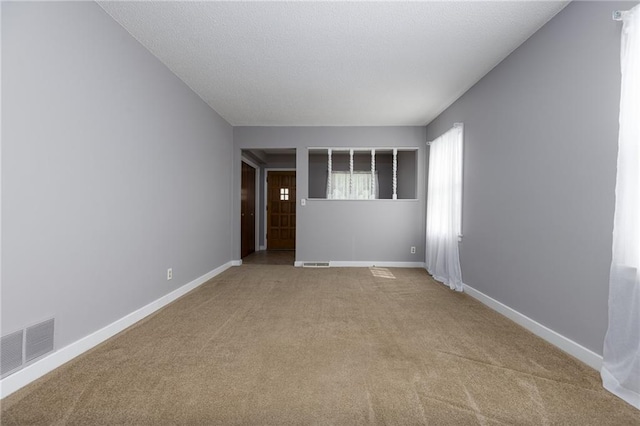 empty room featuring baseboards, visible vents, and carpet