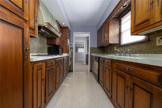 kitchen featuring dishwasher, decorative backsplash, gas cooktop, and a sink