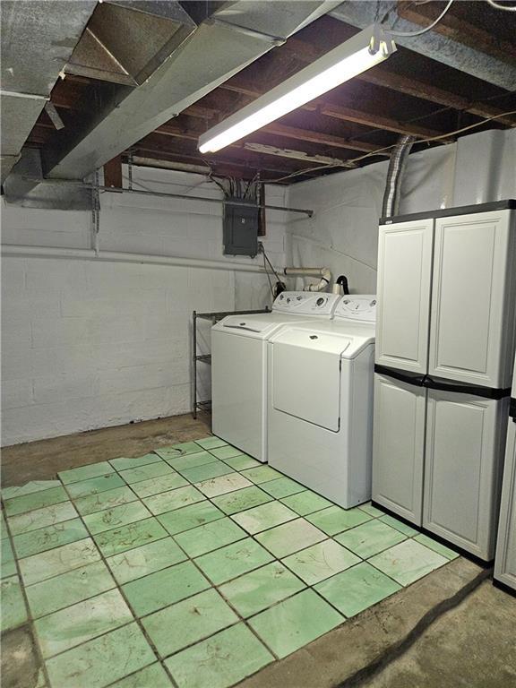 laundry area with cabinet space, washer and clothes dryer, and electric panel